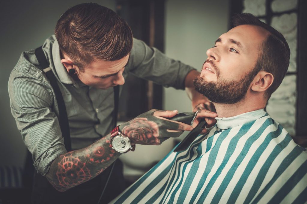 confident-man-visiting-hairstylist-in-barber-shop-.jpg