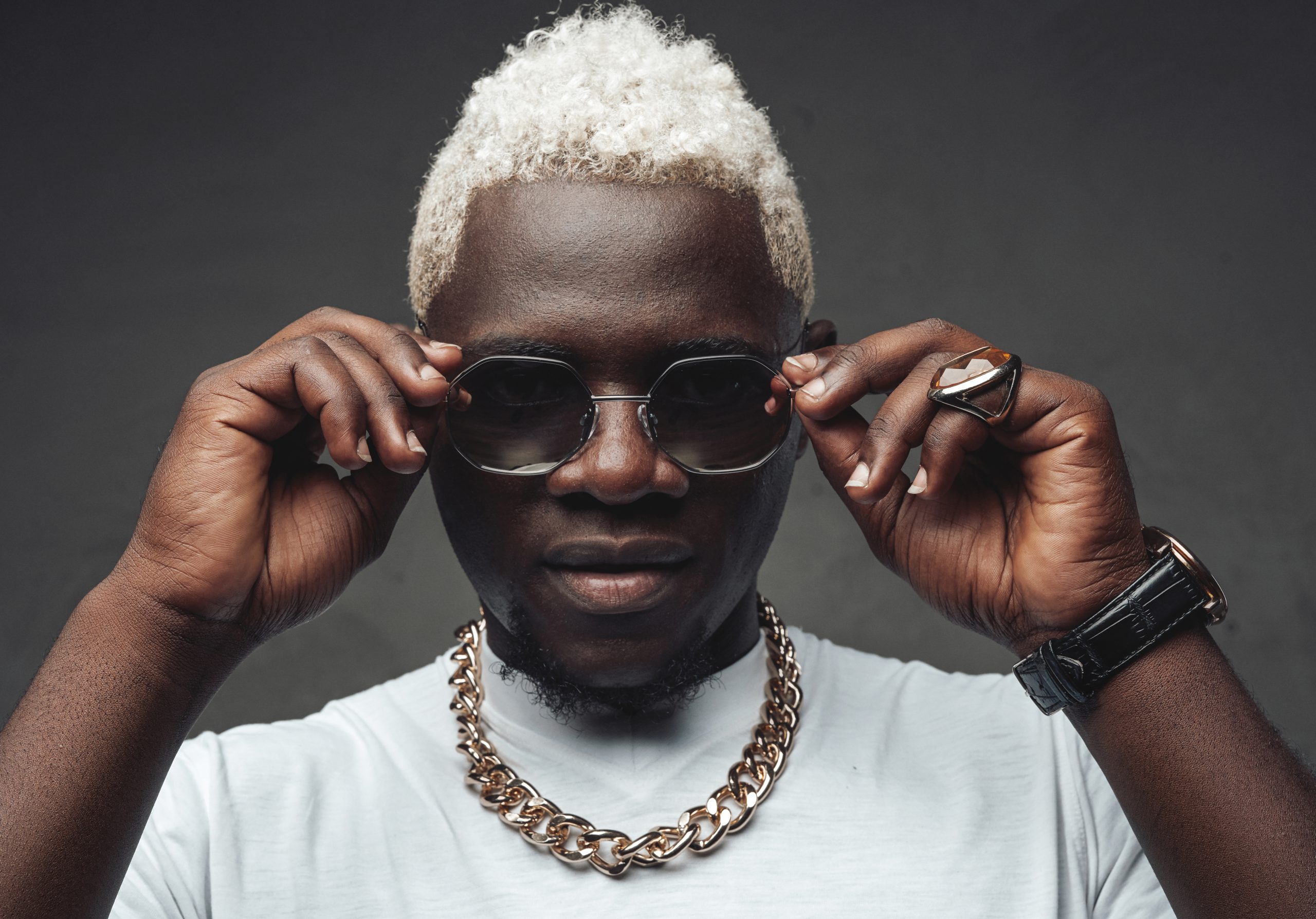 Stylish african man with white hairs holding sunglasses